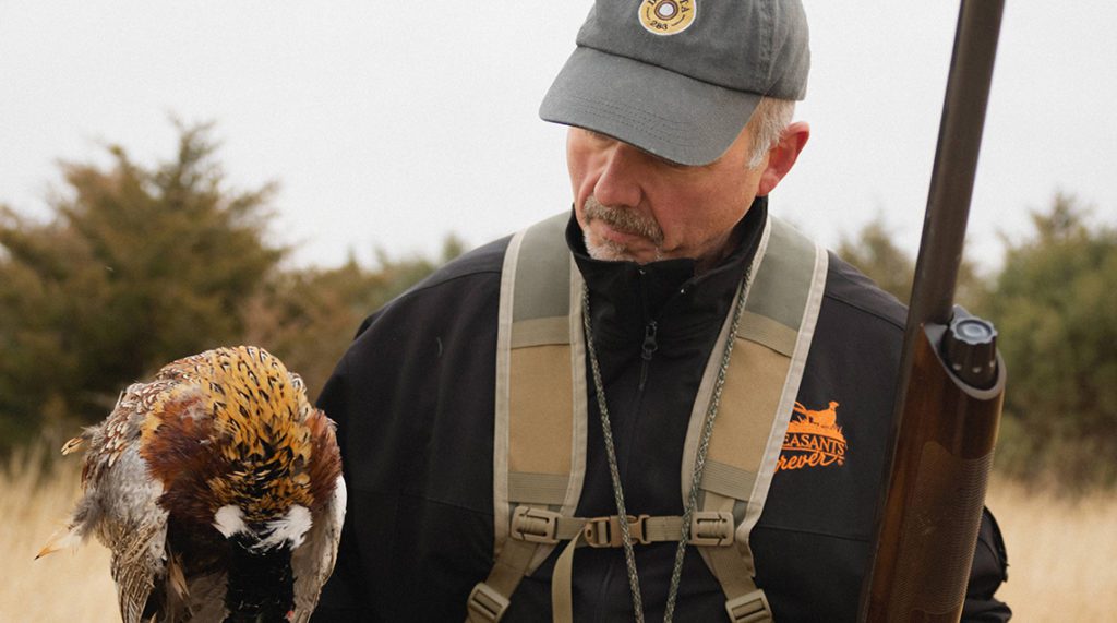 Greg Cronkhite holds a dead pheasant.